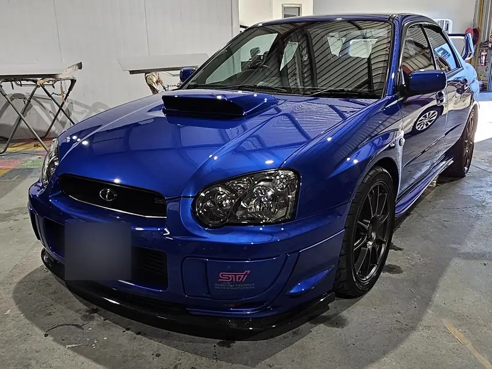 Blue Subaru WRX STI with fresh gloss paint in the spray booth